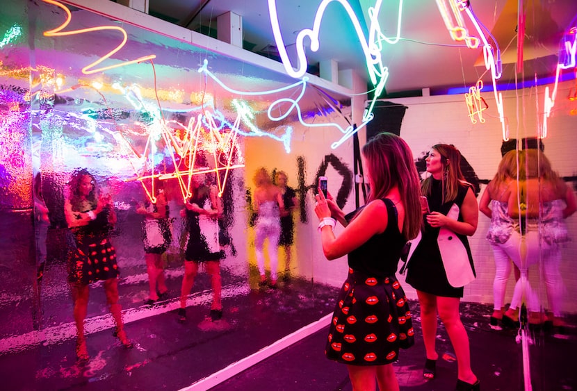 Women take photos inside the last Psychedelic Robot at The Crescent in Dallas. It has moved...