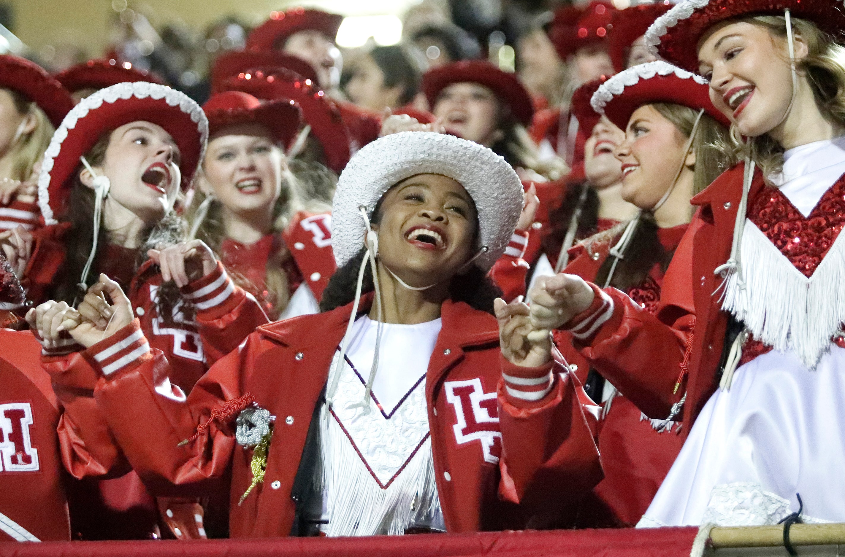 Alyssa McLemore (center) with the Lake Highlands High School Highlandettes cheers the team...