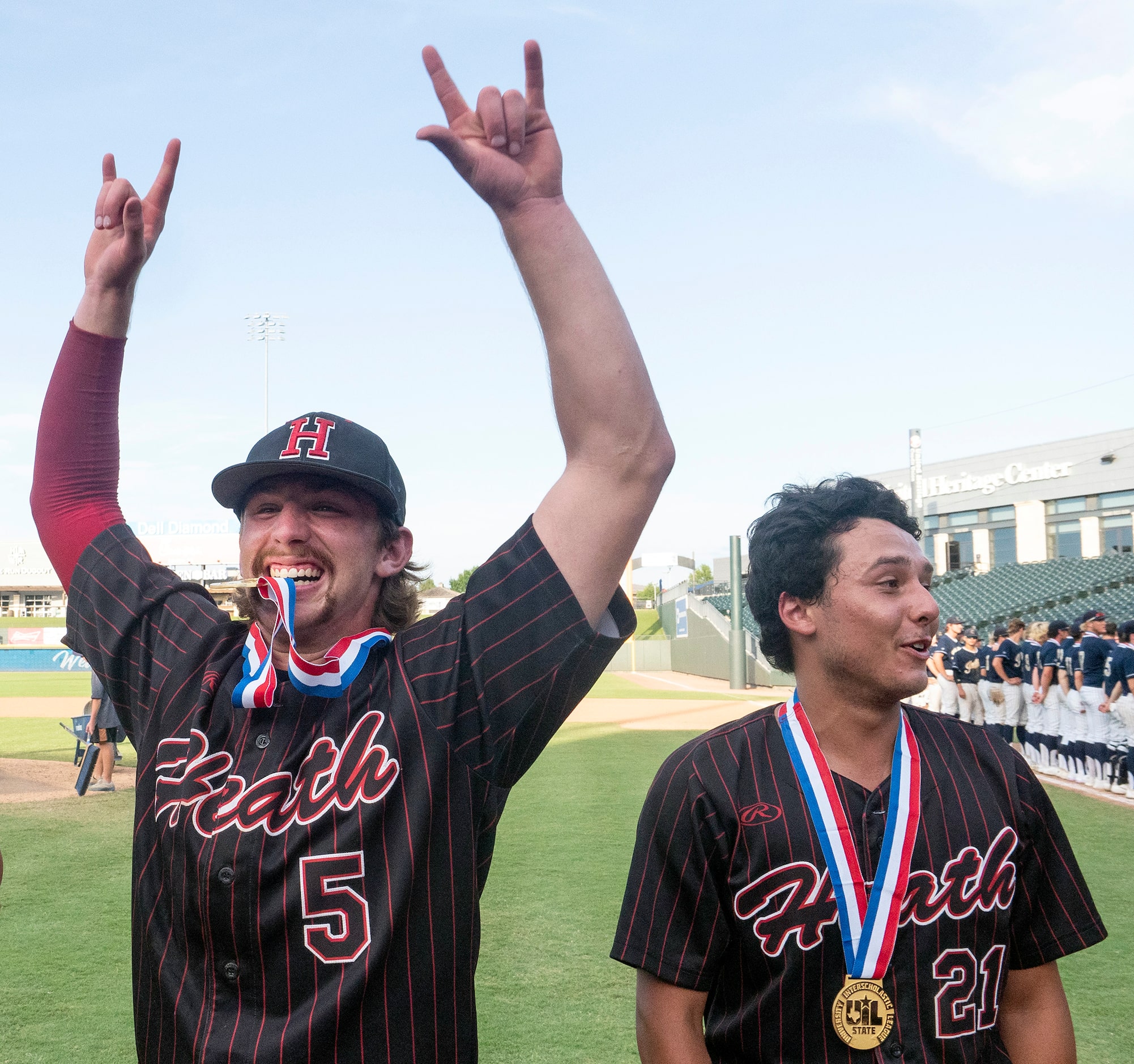 Rockwall-Heath Karson Krowka, (5), center, bites his UIL gold medal as Zach Rike, (21),...