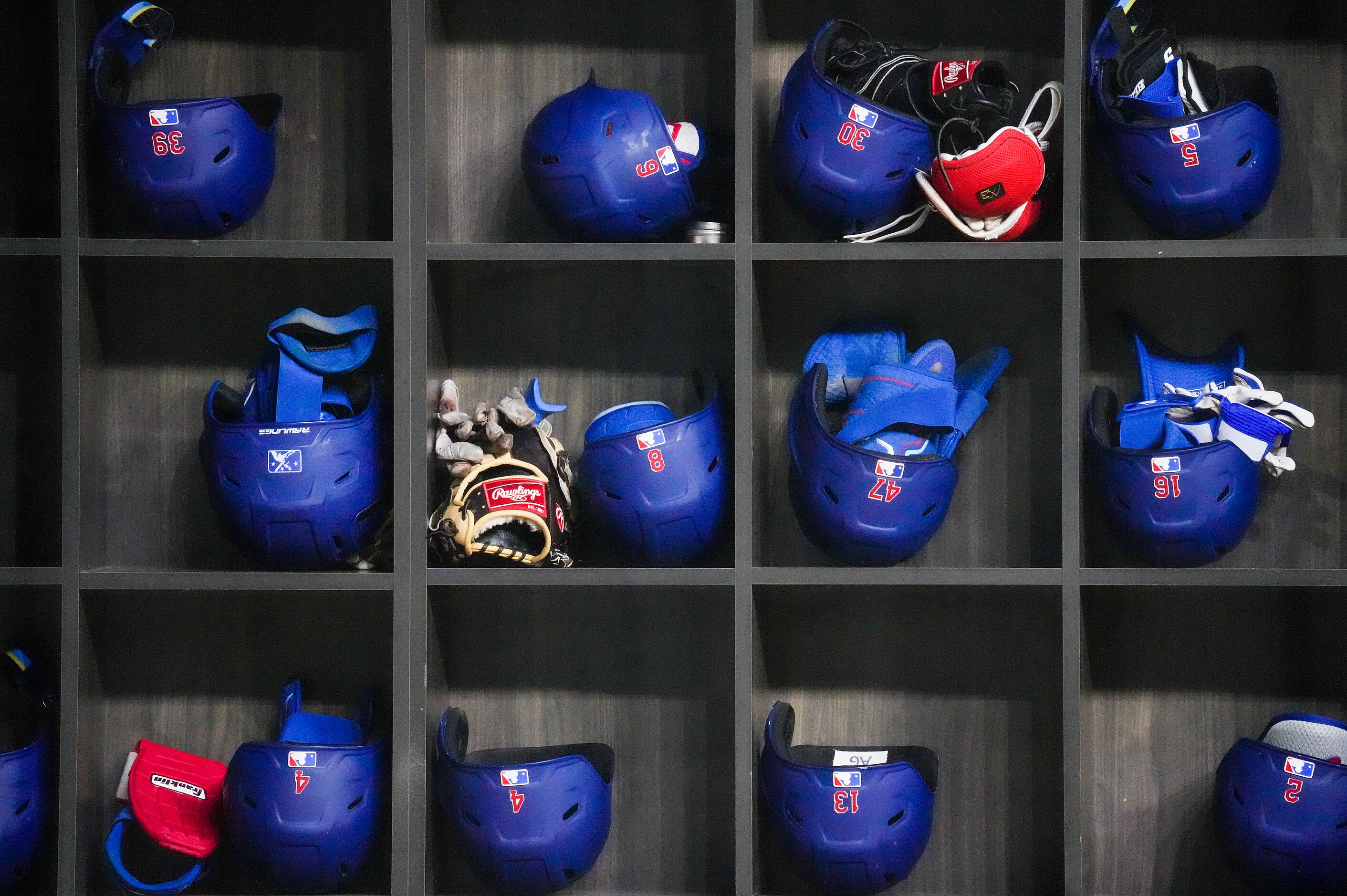 Texas Rangers helmets and gloves in the dugout before an exhibition baseball game against...