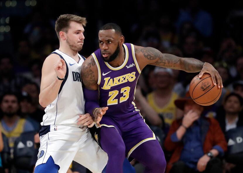 Los Angeles Lakers' LeBron James (23) is defended by Dallas Mavericks' Luka Doncic during...