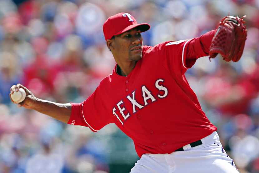 Texas Rangers relief pitcher Alexi Ogando throws during the sixth inning of a 14-10 loss to...