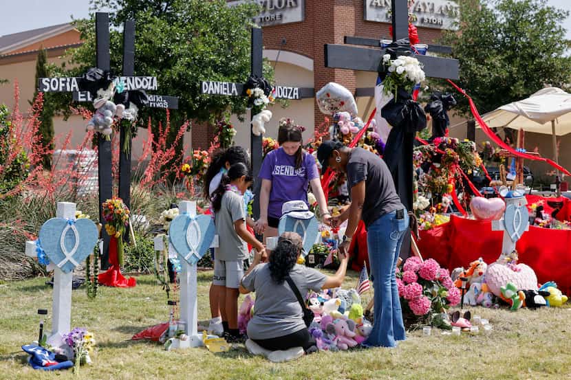People pray around a cross for Sofia Mendoza, 8, at a memorial on Tuesday, May 9, 2023, for...