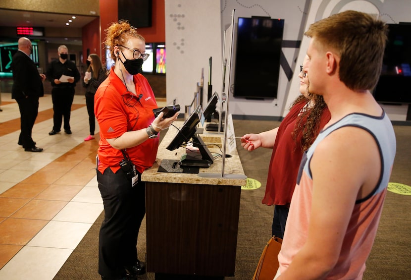 Cinemark's Jennifer Bell (left) scans the tickets of Hannah Potter (center) and Tony Johnson...