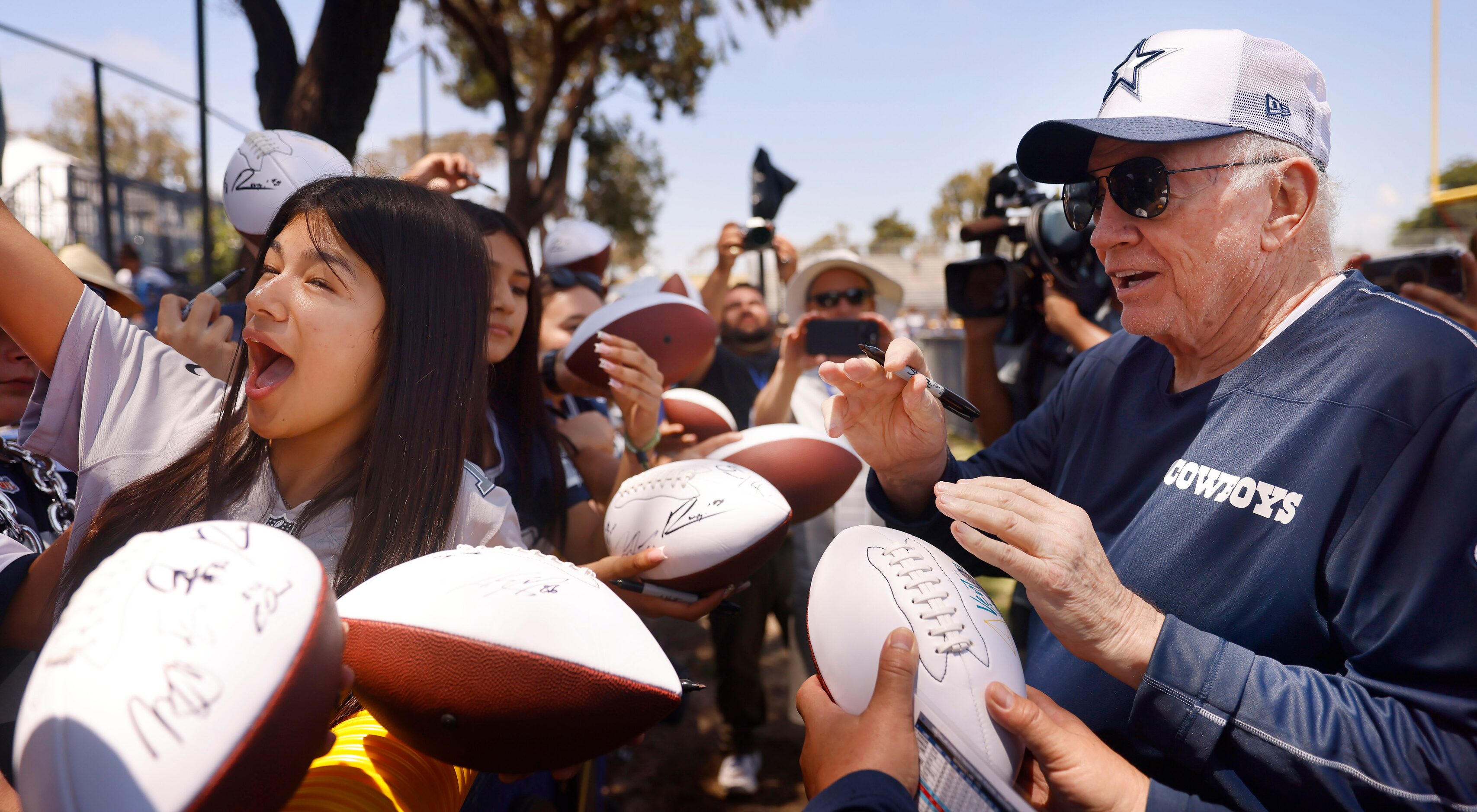 Dallas Cowboys owner Jerry Jones takes a photo with an excited fan following training camp...