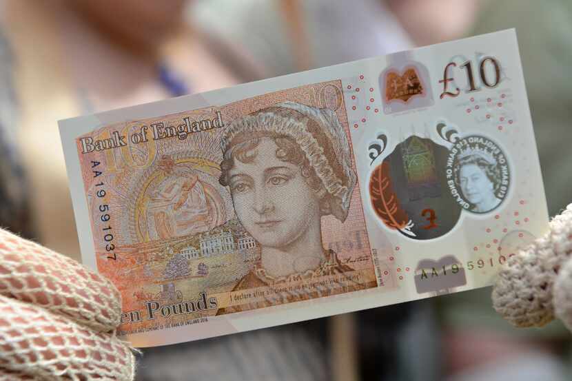 People in period costume pose with one of the Bank of England's new ten pound notes,...