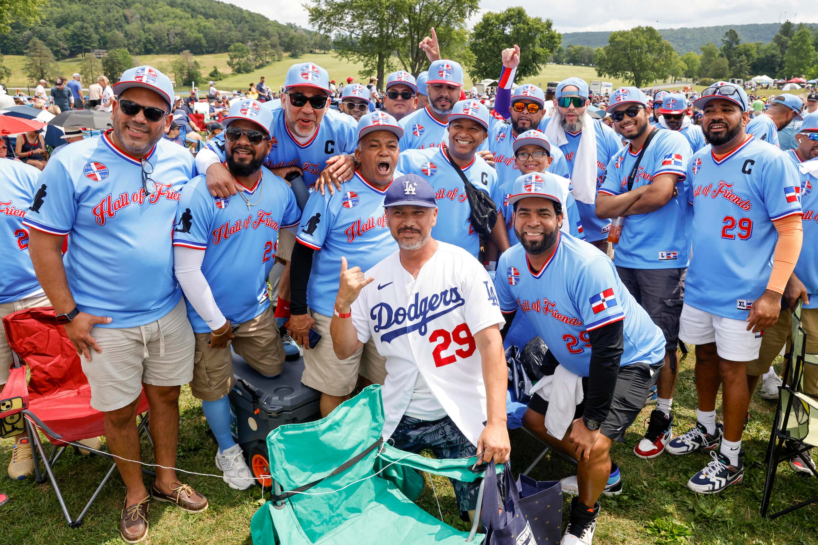 A group of baseball aficionados known as the “Hall of Friends” wear themed shirts for former...