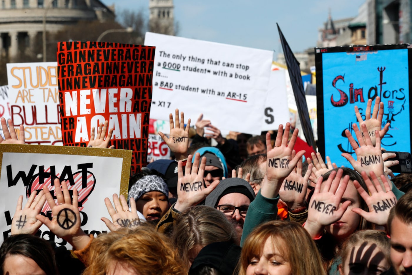 People hold their hands up with messages written on them during the "March for Our Lives"...