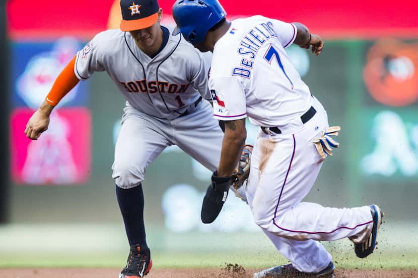 Houston Astros shortstop Carlos Correa (1) makes a late tag on Texas Rangers left fielder...