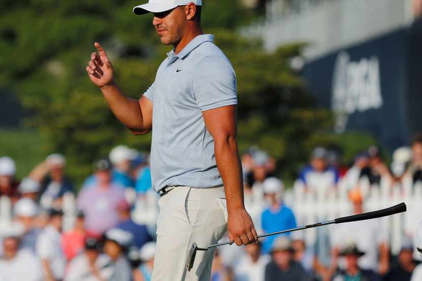 Brooks Koepka acknowledges the gallery as he walks to the 18th green during the third round...