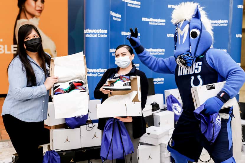 Dallas Mavericks mascot Champ, poses with UT Southwestern healthcare workers after they...