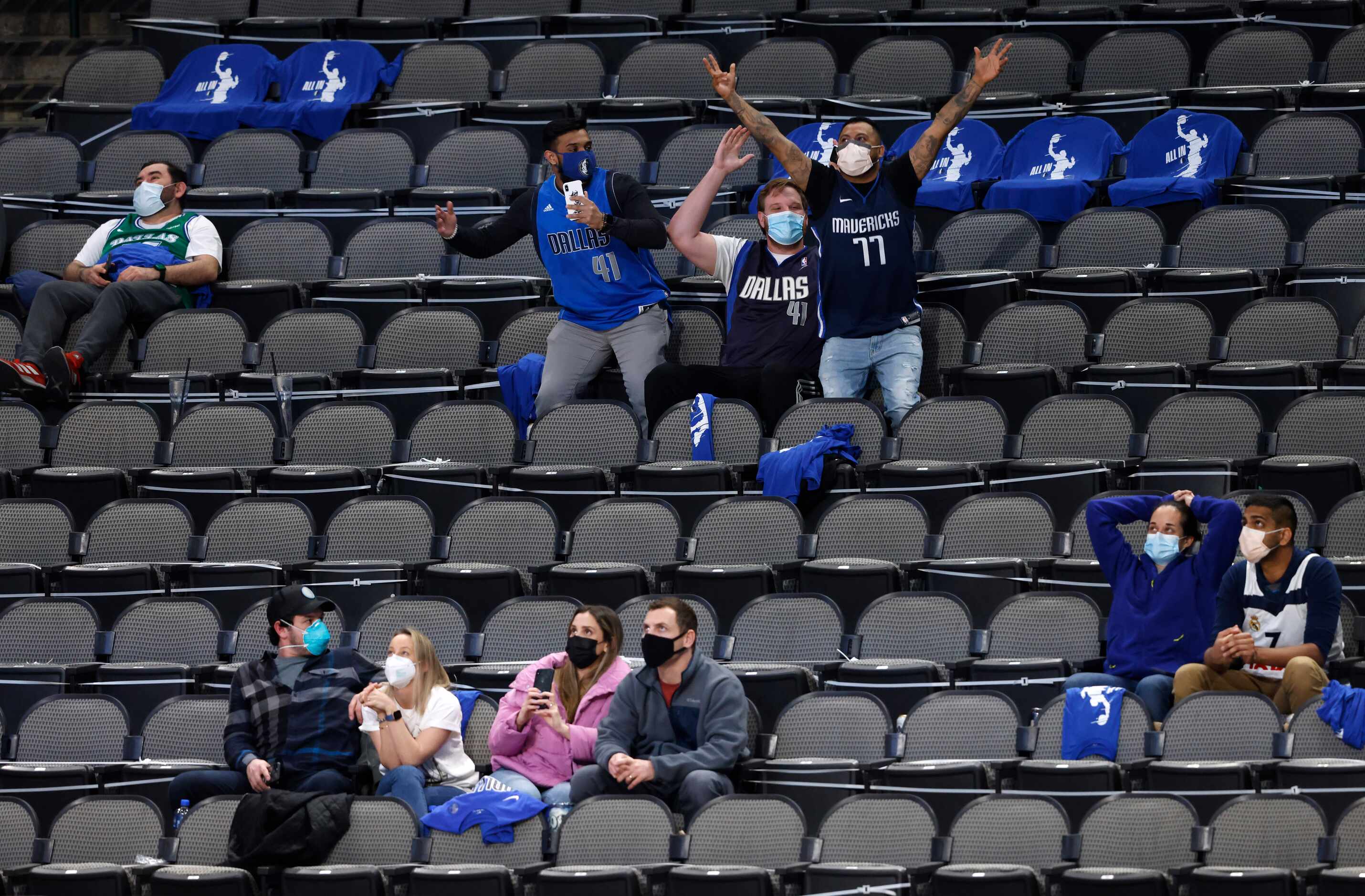 Dallas Mavericks fans celebrate as they are shown on the big screen in a game against the...