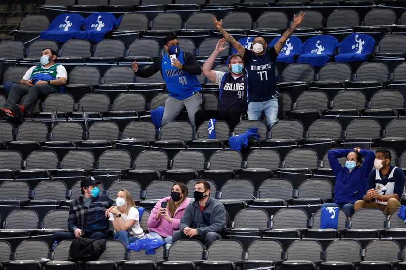 Dallas Mavericks fans celebrate as they are shown on the big screen in a game against the...