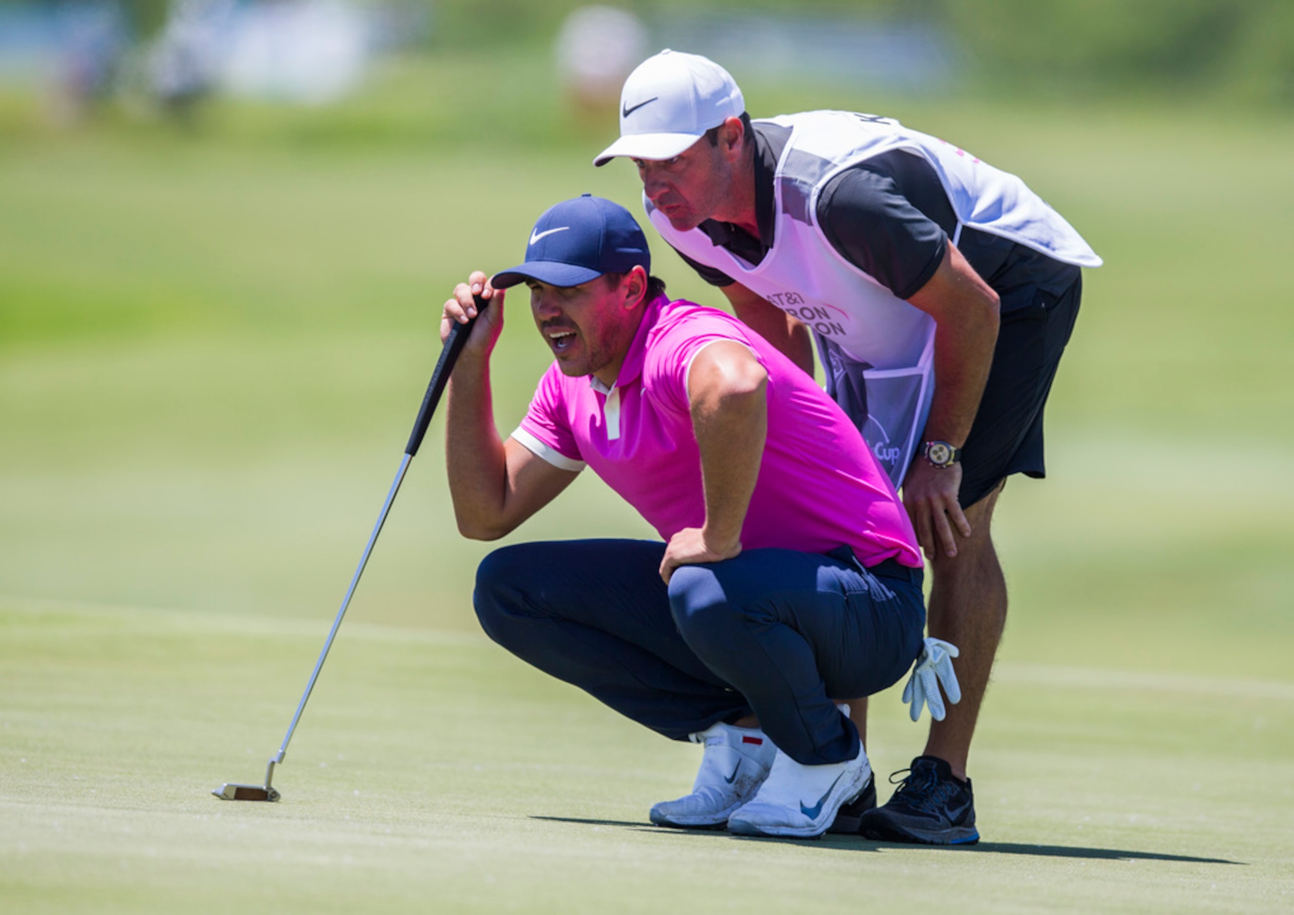 Brooks Koepka and his caddie, Ricky Elliott, line up a shot on the third green during round...