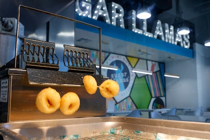 Mini doughnuts flip out of a fryer Sugar Llamas in Rockwall.