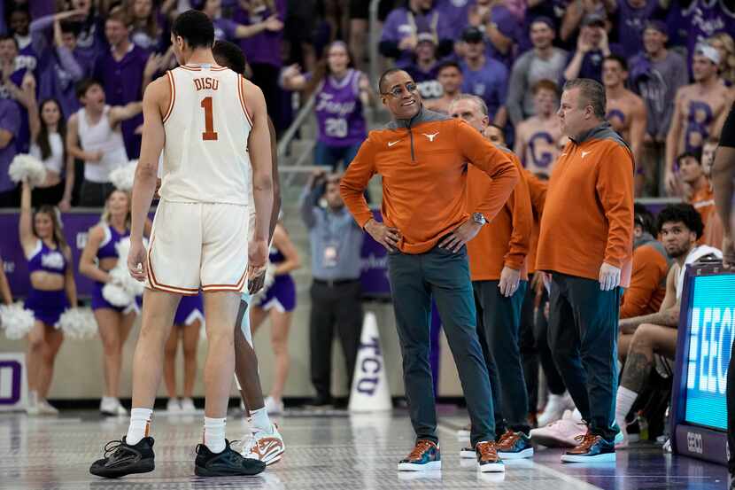 Texas' Dylan Disu (1) and interim coach Rodney Terry, center, stand by the bench after Terry...