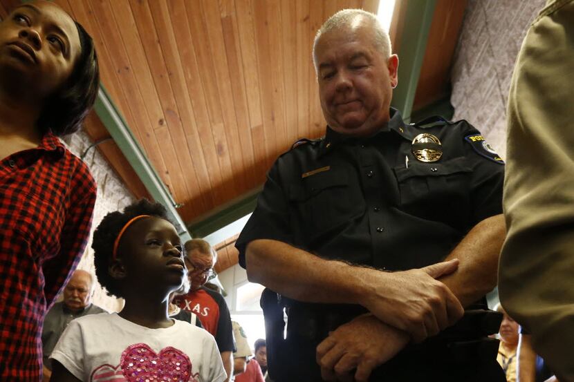 Oluwakemi Ojo, 7, and assistant chief Rodney Thompson attended the prayer service Friday at...
