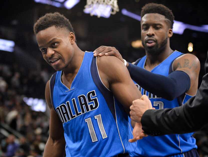 FILE - Mavericks guards Yogi Ferrell (11) and Wesley Matthews leave the court after a game...