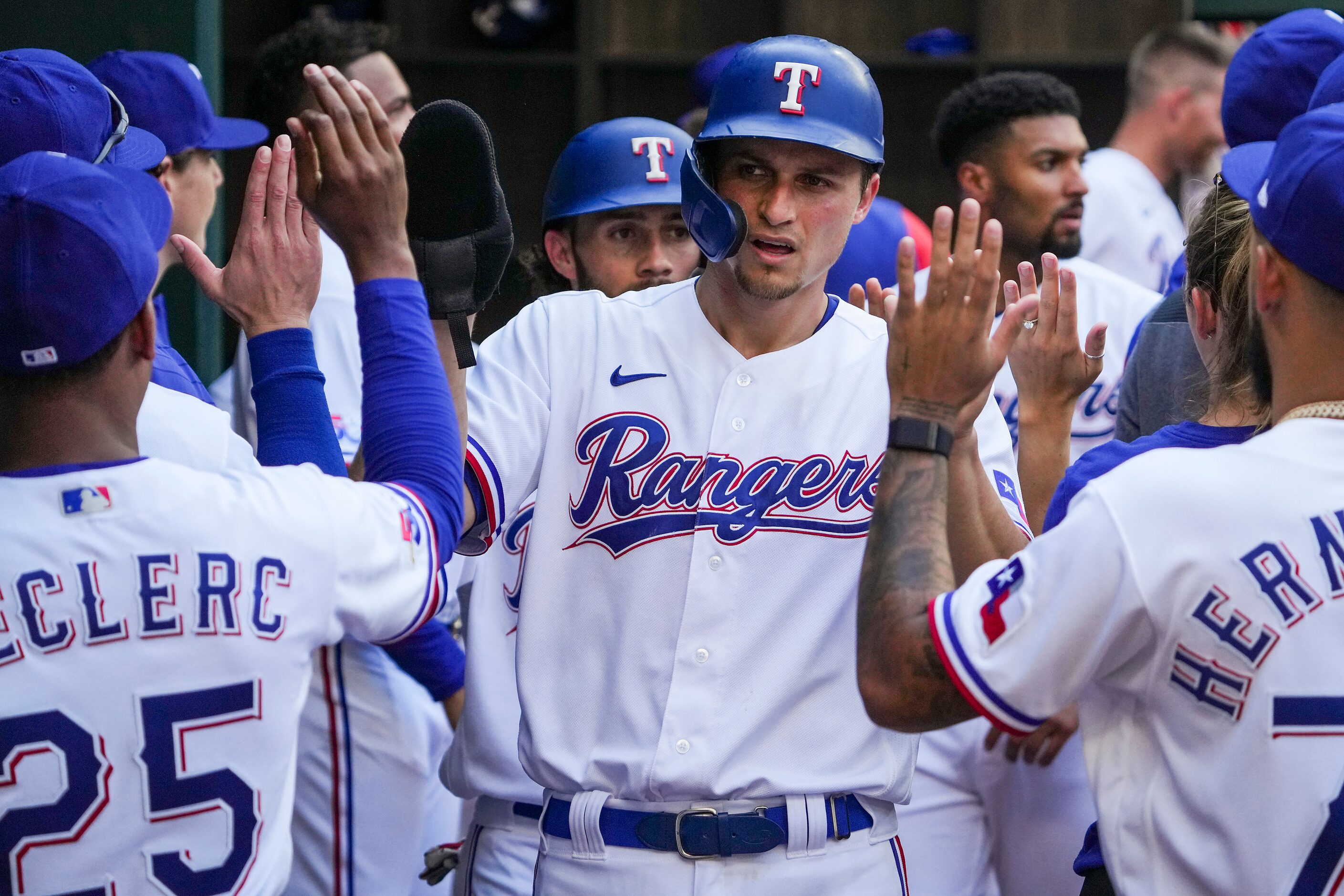 Texas Rangers shortstop Corey Seager celebrates with teammates after scoring during the...