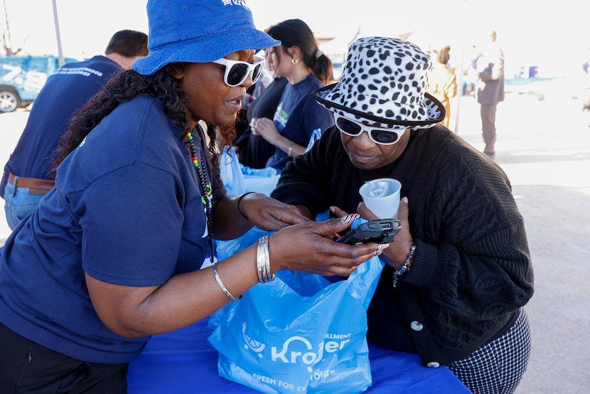 Latasha McCoy with Kroger (left) reviews Thelma Warren’s grocery pickup order with her...