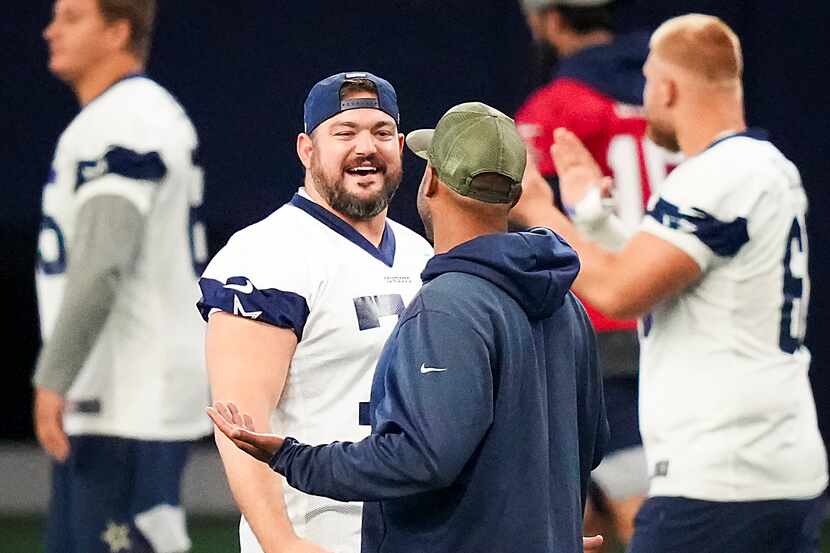 Dallas Cowboys offensive lineman Zack Martin (70) laughs with defensive line coach Aden...