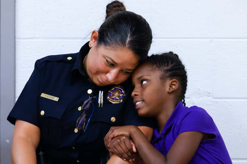 Assistant Chief of the Dallas Police Department, Angela Shaw, left, spends a moment with...