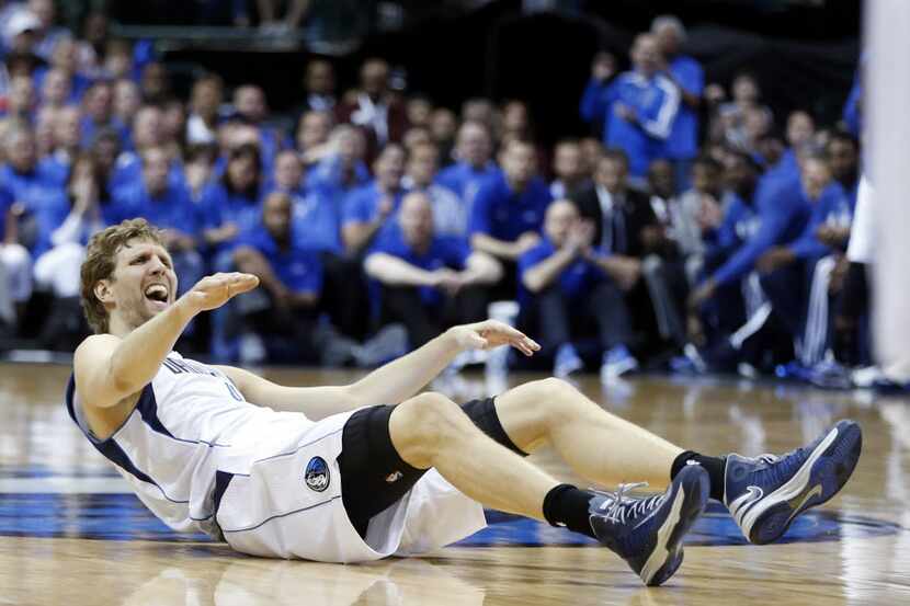 Dallas Mavericks forward Dirk Nowitzki (41) lies on the floor and reacts after being fouled...