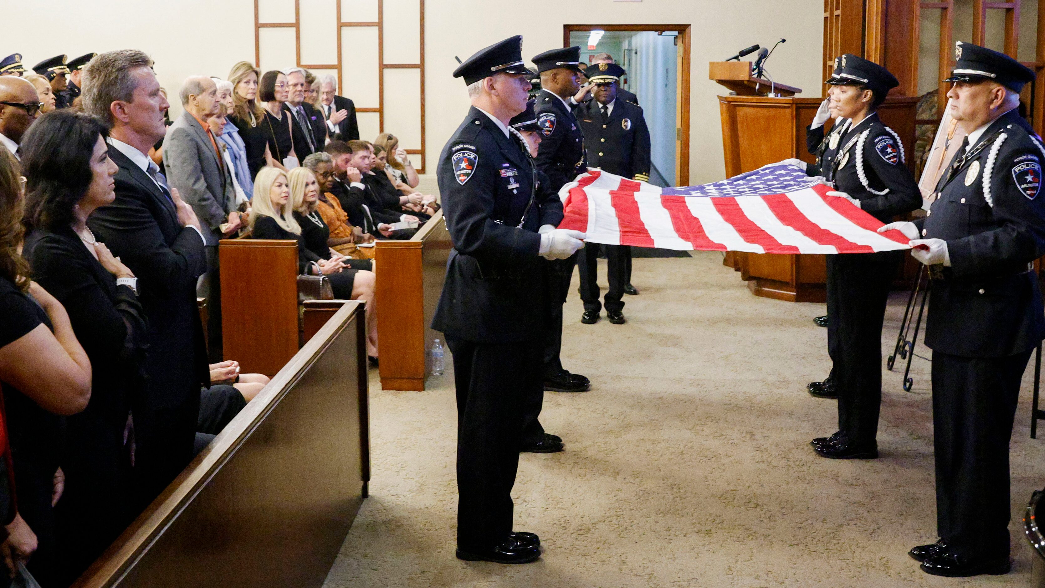 Mourners stand during a flag fold ceremony during the funeral service for former Dallas...