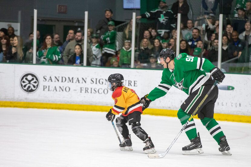 The EKG's left winger Anderson McDuffie, left, gets help maintaining his balance from Dallas...