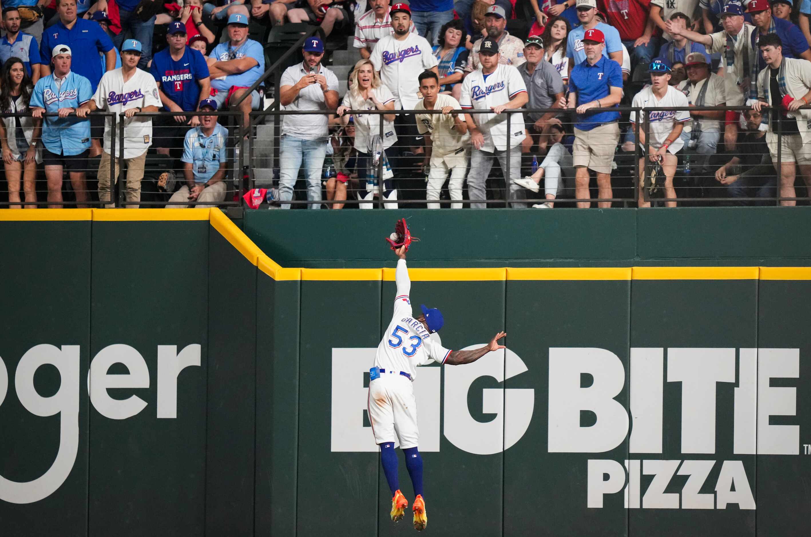 Texas Rangers right fielder Adolis Garcia makes a leaping catch on a fly ball from Arizona...