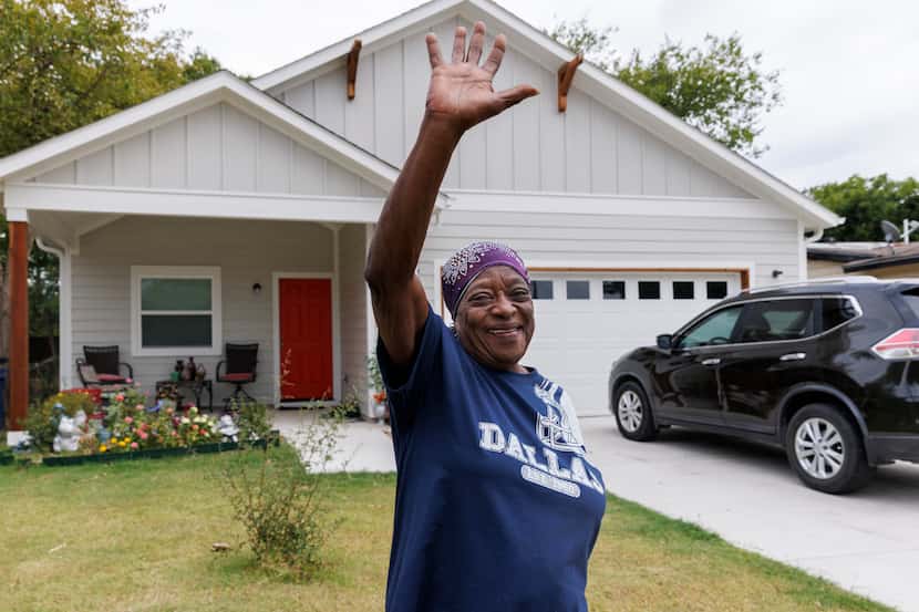 Zeta White waved to a school bus driver as she stands outside her home on Sept. 15 in...