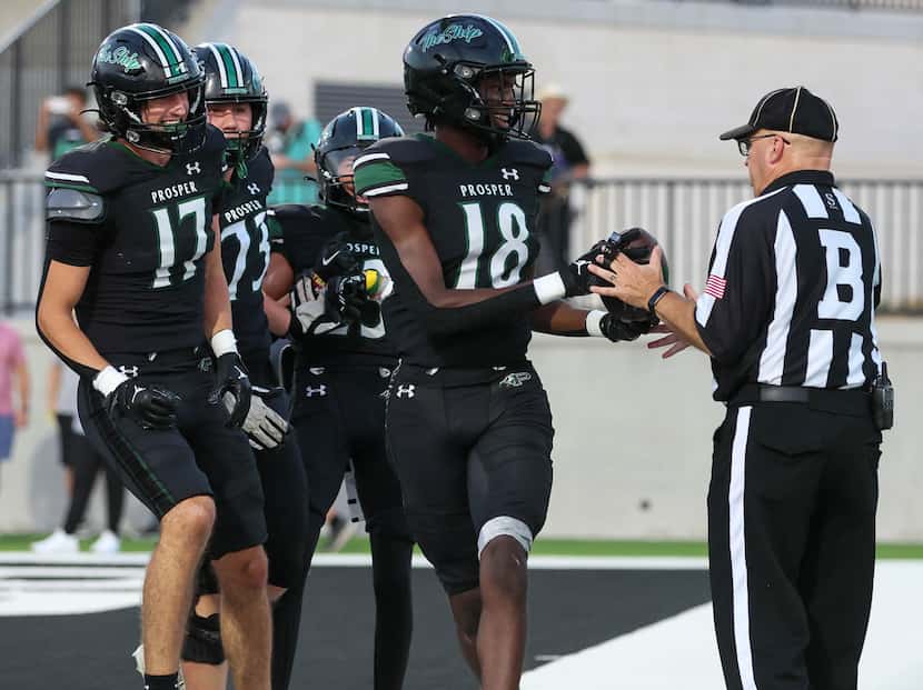 Prosper wide receiver Jayden Beasley (18) hands the ball to the back judge after a touchdown...