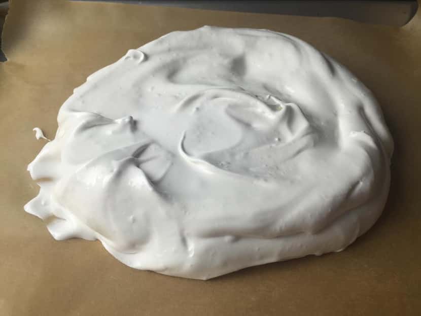 Raw meringue is then spooned onto a parchment-lined baking sheet, ready to go in the oven