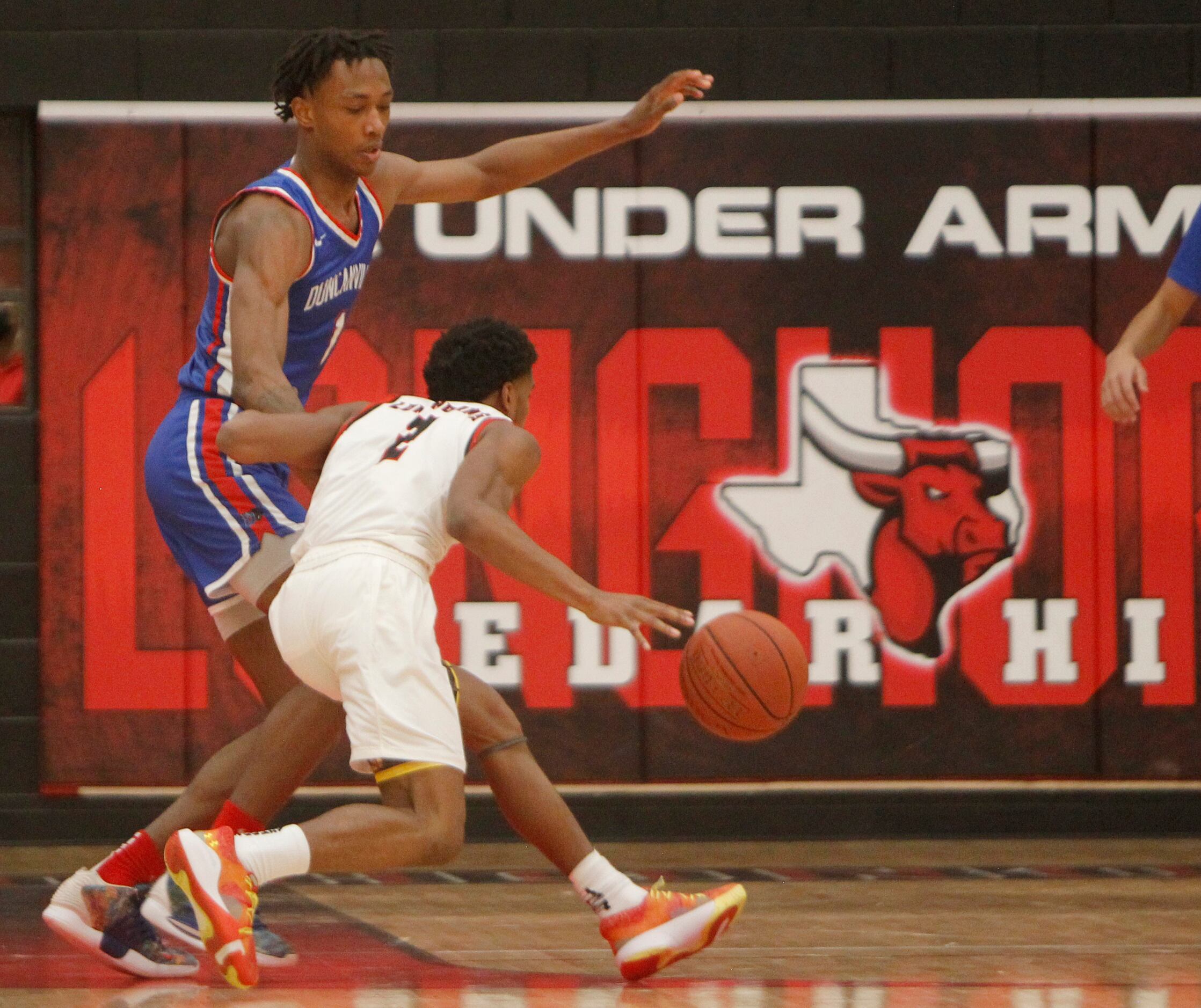As a banner message suggests in the background, Cedar Hill's Jason Justice (2) dribbles...