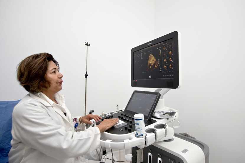 Una doctora ve una imagen de un corazón en una computadora.
