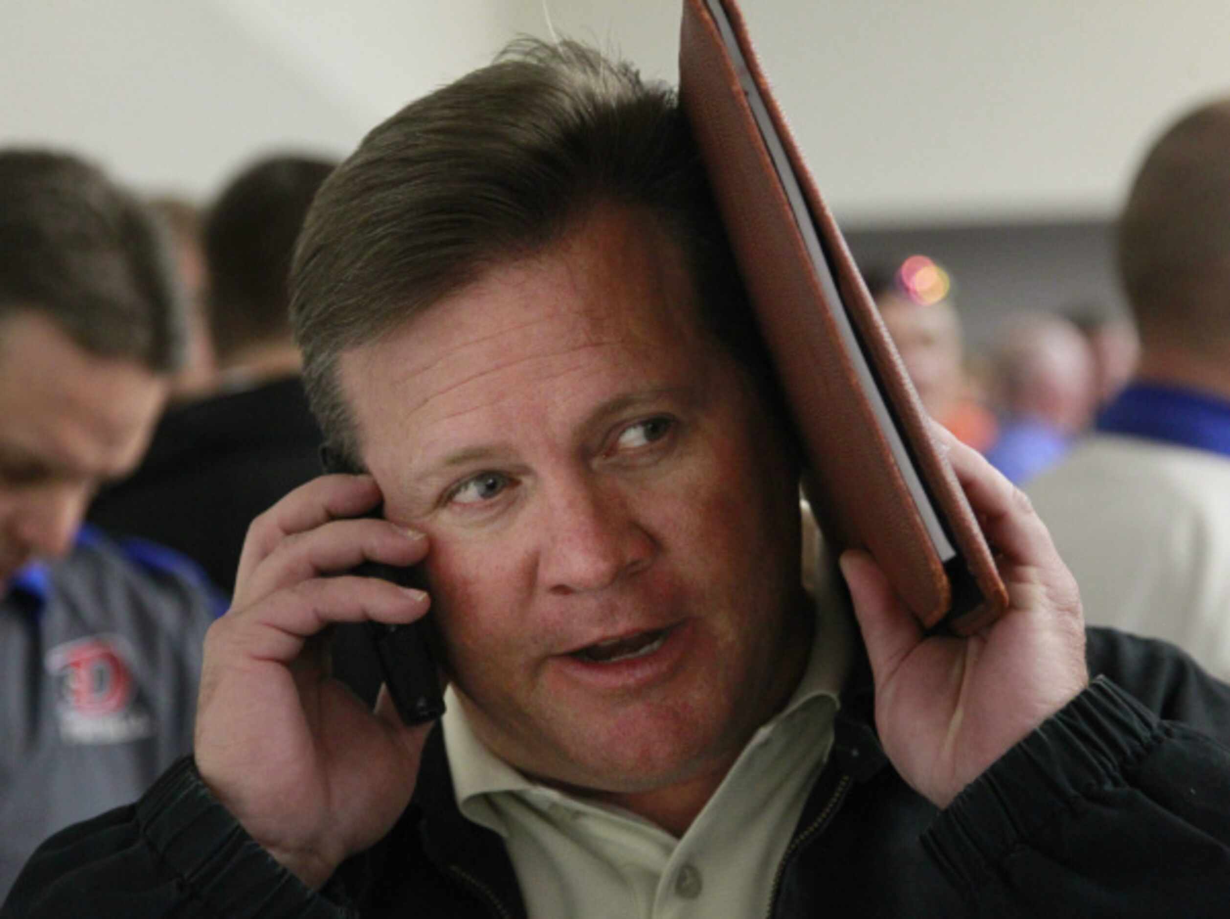 Denton Ryan Football coach Joey Florence tries to hear a phone call from another coach...