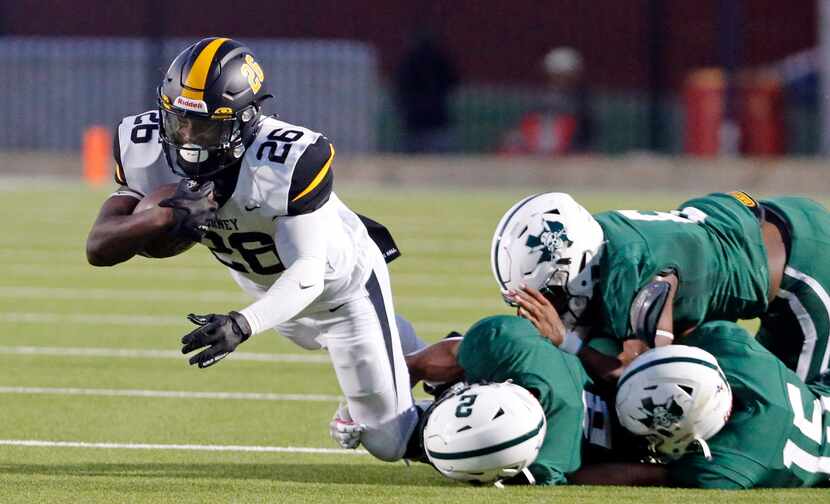 Forney High RB Javian Osborne (26) drags several Mesquite Poteet defenders along with him,...