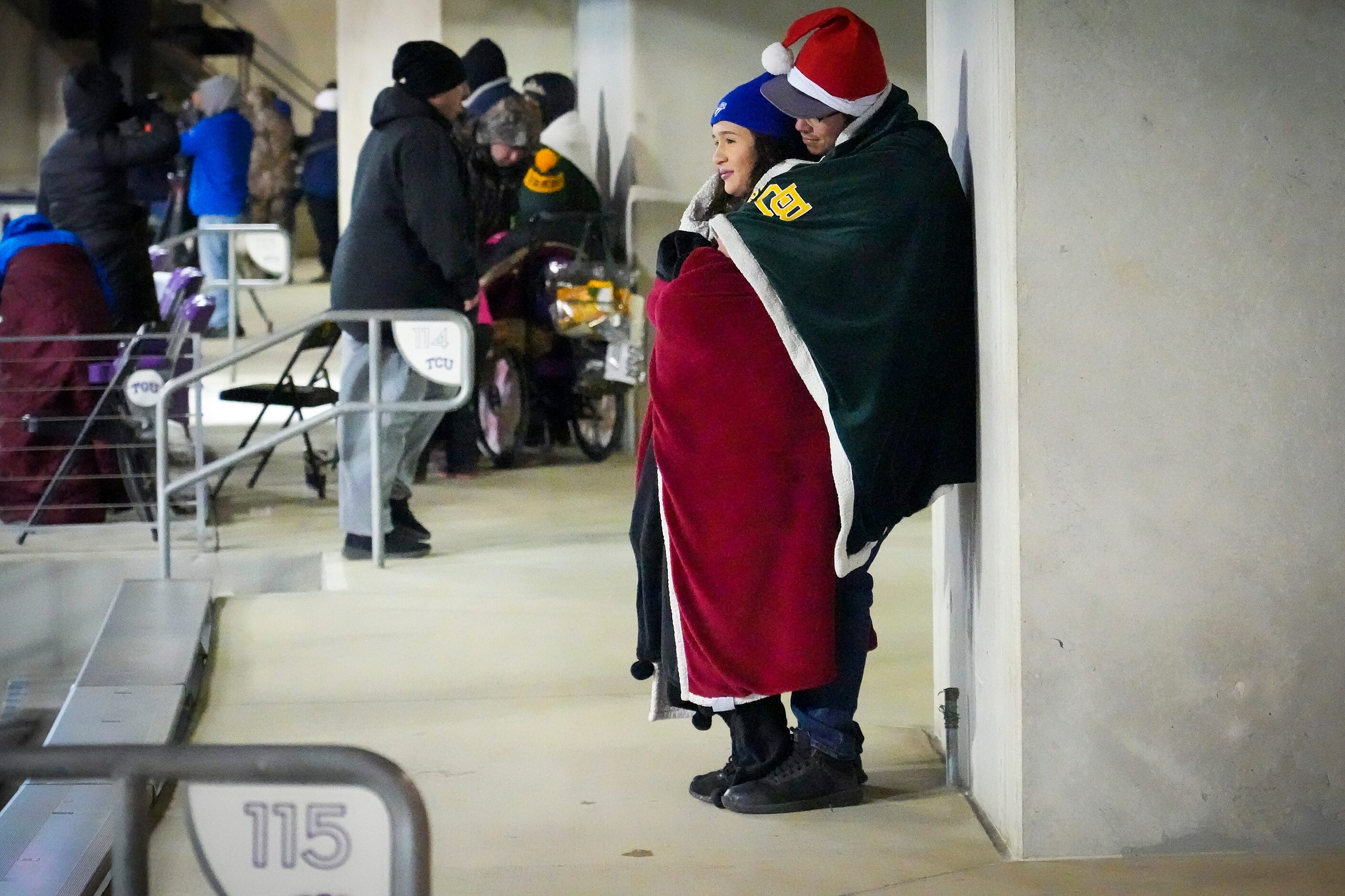 Fans huddle against cold temperatures during the first half of the Armed Forces Bowl NCAA...