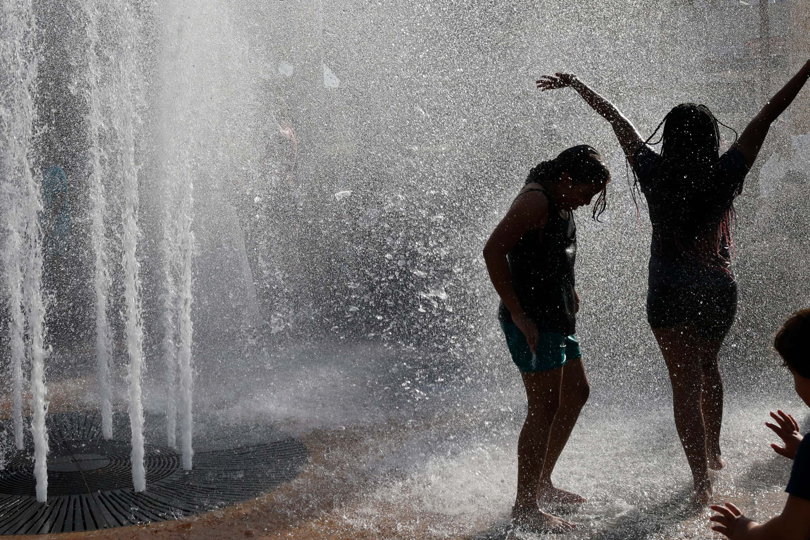 Children cool off in a water fountain during the Fair Park Fourth celebration in Fair Park,...