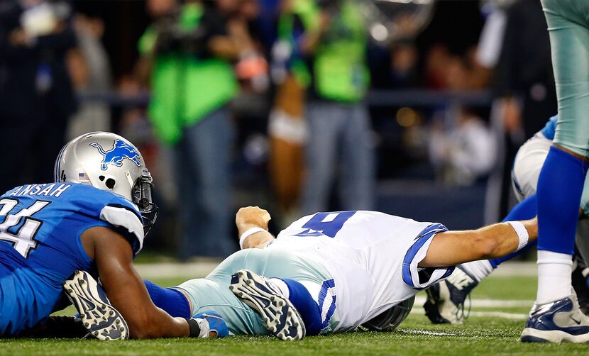 ARLINGTON, TX - JANUARY 04:  Tony Romo reacts as he lays on the ground after throwing a...