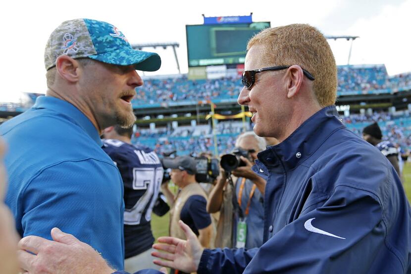 Dallas Cowboys head coach Jason Garrett, right, shakes hands with Miami Dolphins head coach...