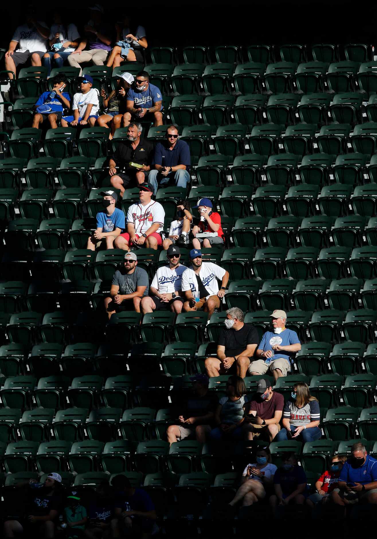 Los Angeles Dodgers and Atlanta Braves fans are seated socially-distanced in the right field...
