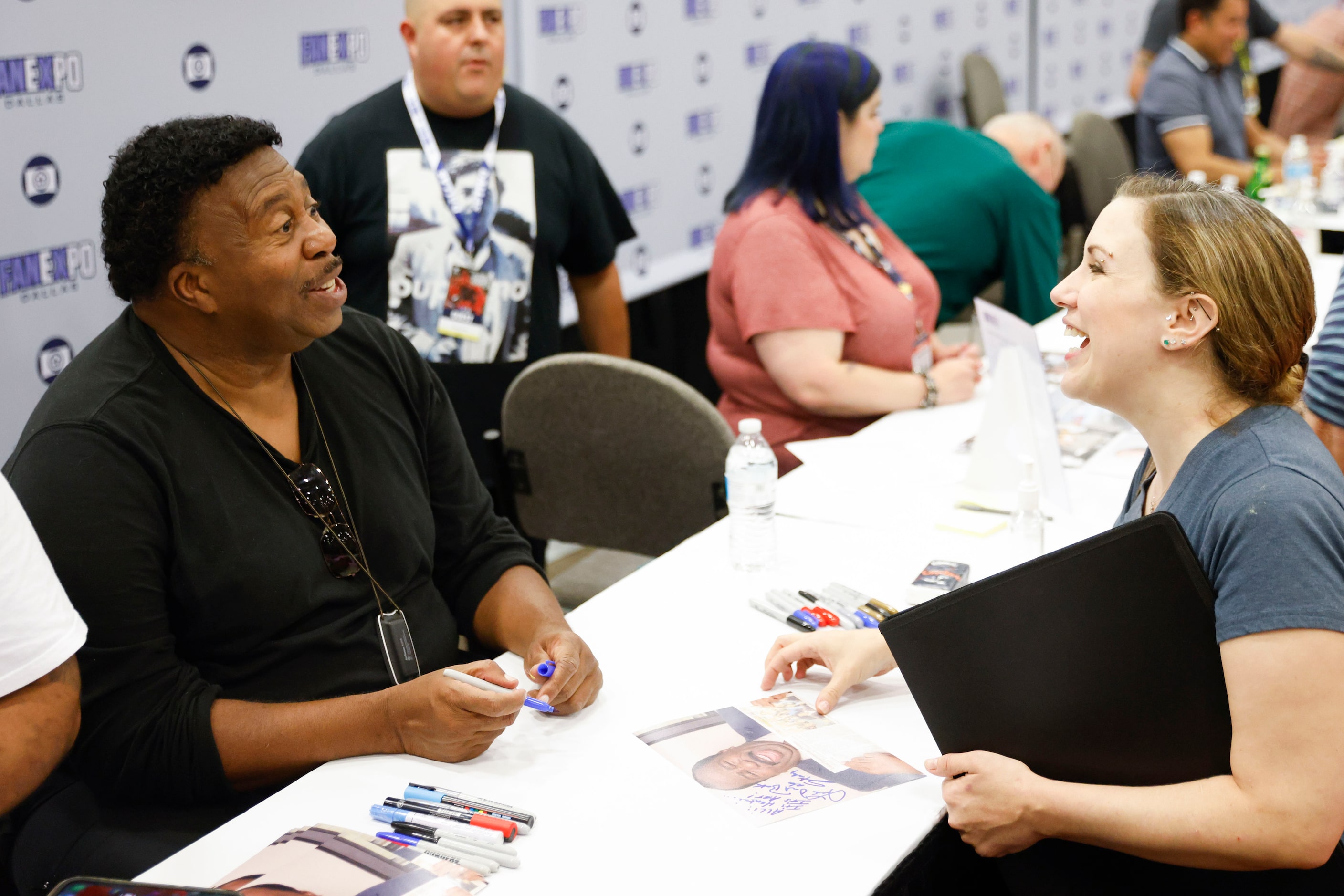 Actor Leslie David Baker (left) of the Office reacts while giving autographs to fans during...