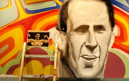 A photograph of Larry North is used to paint his likeness on a mural.  (Nathan Hunsinger/The...