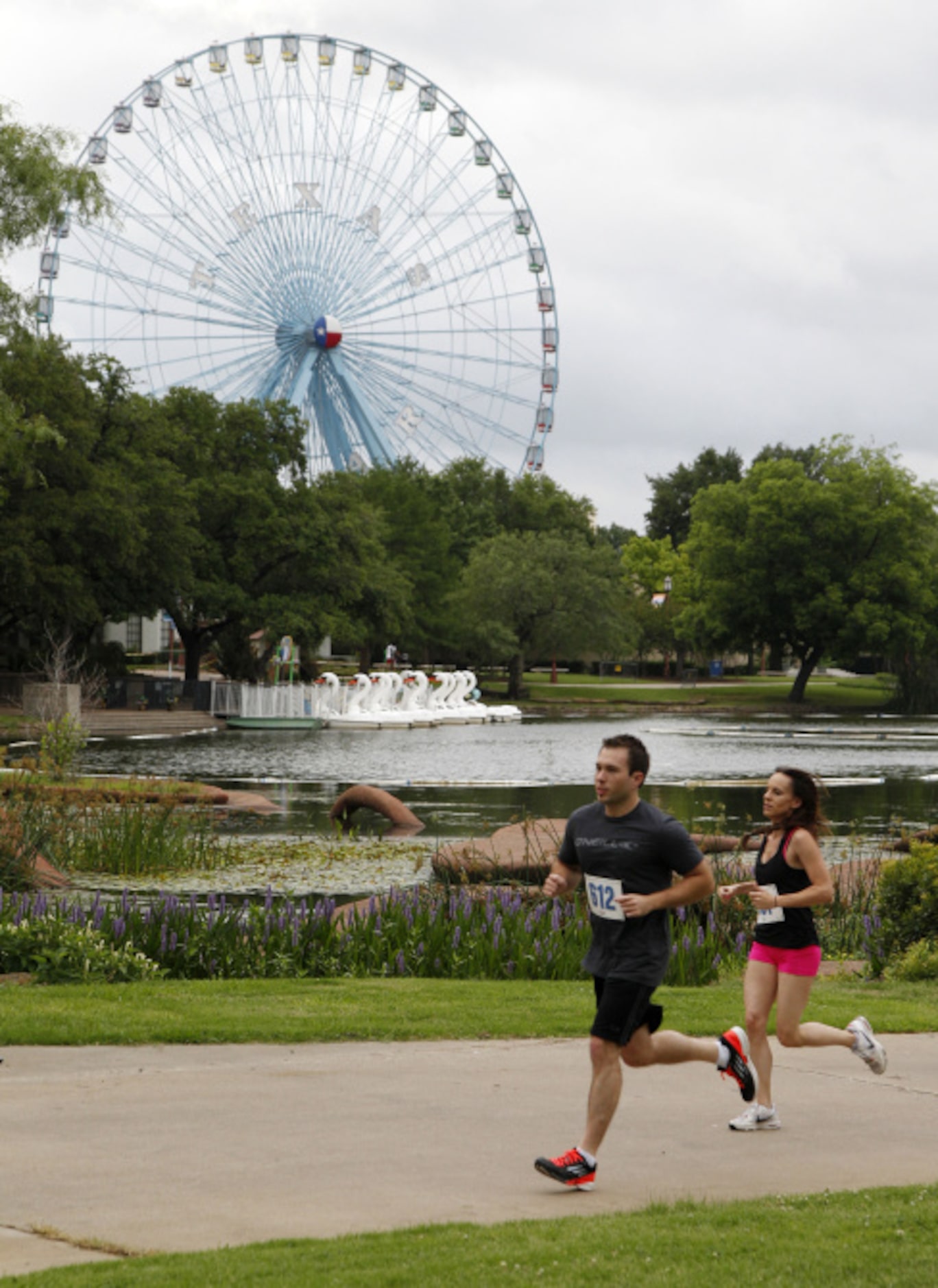 Rudy Samboruk, front, and Sloan Shearer, run past the lagoon and Texas Star during the...