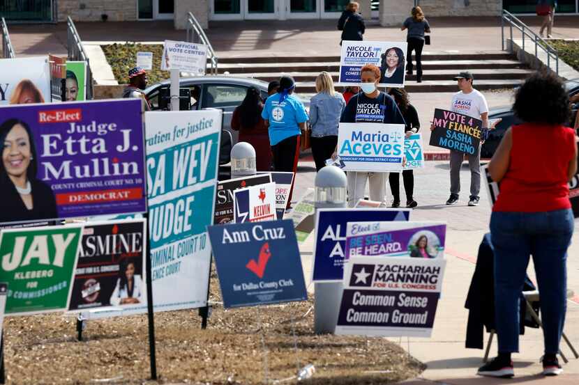 Campaign volunteers approach voters as they enter the Simms Cedar Hill Recreation Center in...