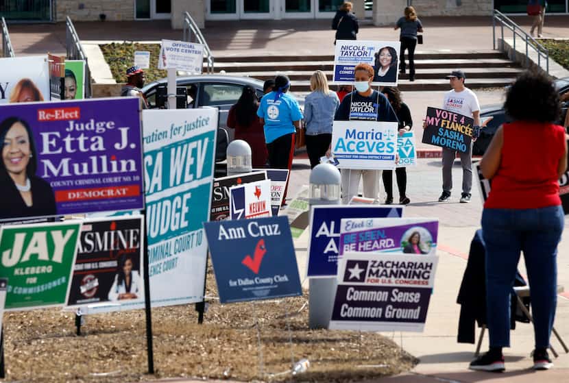 Campaign volunteers interacted with prospective voters at a polling center in Cedar Hill on...