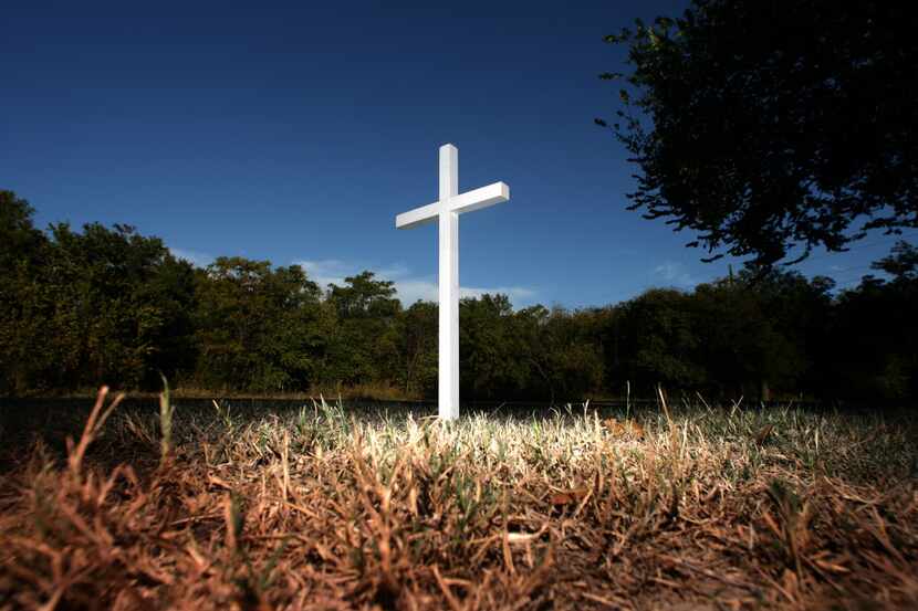 
A small white cross stands alongside the White Rock Creek Trail near the Walnut Hill...