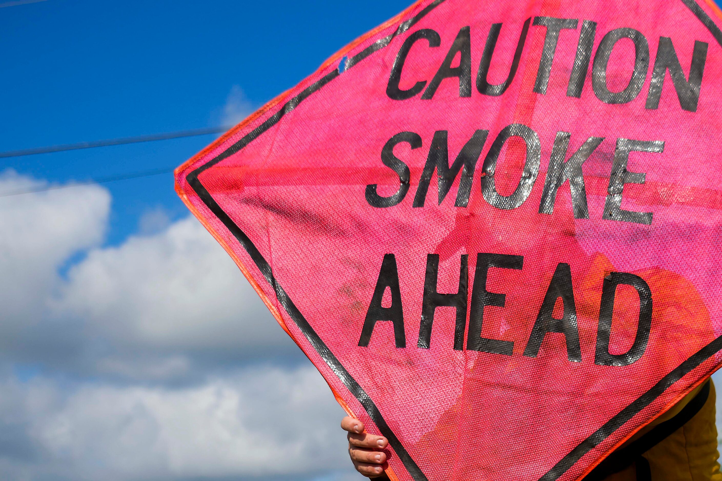 Lucien Ball sets up road signs alerting motorists before a prescribed burn at the Roy E....