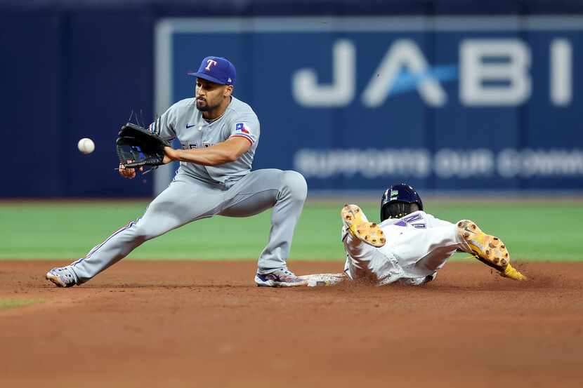 Tampa Bay Rays' Randy Arozarena, right, steals second base as Texas Rangers' Marcus Semien,...